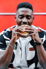 ✓ free for commercial use ✓ high quality images. Ethnic Guy Eating Tasty Burger By Alina Hvostikova