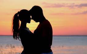 una pareja besandose en la puesta del sol