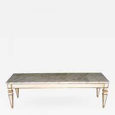 The surface has a brass border atop a frieze with two dummy drawers and two operative drawers. Rectangular Marble Top Coffee Table In The Louis Xvi Style