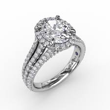 Stunning, this diamond halo bridal set featuring an engagement ring with a white gold split cathedral shank. Fana Oval Diamond Halo Engagement Ring With Triple Row Diamond Band Meritage Jewelers