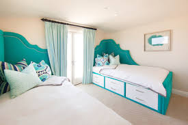 .chandelier over teal velvet headboard on full bed dressed in white and teal bedding, teal monogrammed shams, white and teal chevron duvet, hot pink bolster pillow and teal ruffled bedskirt. Teal Headboard Contemporary Bedroom Brooke Wagner Design