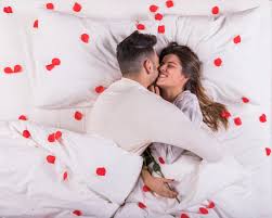 10 surprises pour le faire craquer. Homme Embrassant Une Femme Au Lit Avec Des Petales De Rose Photo Gratuite