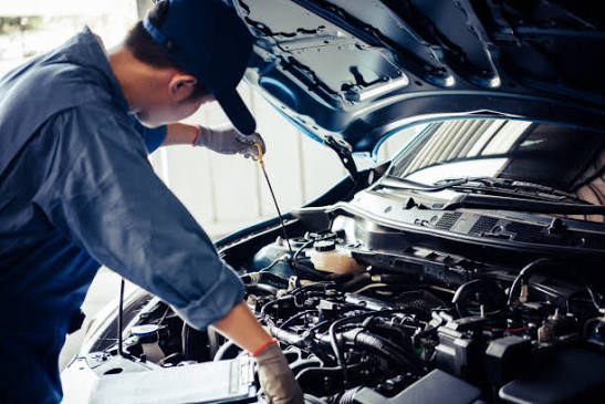 Mechanic working on a car in a garage workshop