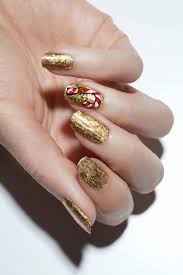 Uñas bellísimas con diseño que combina uñas lisas doradas, uñas blancas con detalle animal print en negro y dorado, y una uña negra con detalle de piedras cuadradas doradas. 1001 Ideas De Bonitos Y Elegantes Disenos De Unas Navidenas