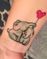 Cute Two Baby Elephants With Balloon Tattoo On Wrist Baby Elephant Tattoo Elephant Tattoo Design Elephant Tattoos