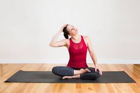 Athletic woman in gray clothes is practicing yoga in bound revolved horse pose on sport mat at home. Warming Up And Cooling Down Yoga Lexiyoga