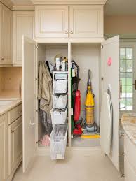 Build it in to the bottom of of your chosen cabinet and simply sweep the dust and dirt towards it. Furniture Comely Traditional Beige Broom Storage Cabinet With Modern Red And Yellow Vacuum Cleaner Also Laundry Room Design Broom Storage Laundry Room Storage