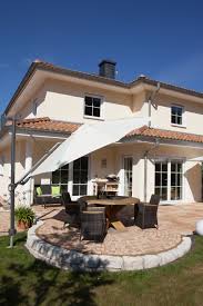 Ein Runder Gestalteter Sitzbereich Mit Sonnenschirm Ist In Die Terrasse Mit Medino Platten Integriert Terrassenplatten Toskana Haus Terassen