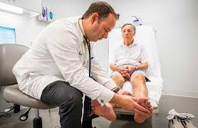 Doctor examining a patient's legs during care for a clotting or circulation disorder