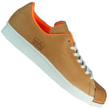 Diese version wurde hier noch mit einer zusätzlichen die schwarzen adidas superstars mit weißen streifen an den seiten und weißen elementen an der ferse, sind eine der beliebtesten versionen des klassikers. Adidas Superstar 80s Clean Originals Retro Herren Sneaker Braun Orange Weiss Meinsportline De