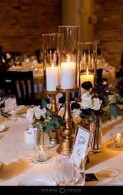 Tall Candles In Gold Candleholders And White And Maroon Flowers In Small Vases F Gold Wedding Centerpieces Wedding Table Centerpieces Tall Wedding Centerpieces