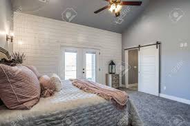 A green floral material wraps the walls like the woods outside and continues onto the bed, a bench, and the curtains. Amazing Master Bedroom With Shiplap Walls And Vaulted Ceiling Stock Photo Picture And Royalty Free Image Image 147552198