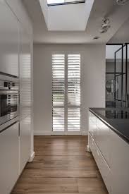 mooie kamerhoge witte shutters in moderne keuken spelen met licht en eenvoudig schoon te maken witte luiken moderne keukens keuken raambekleding
