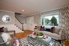 View in gallery although it can seem austere, a grey room can be very relaxing. Two Tone Living Room Walls Around Neutral Sofa Layered Glass Coffee Table And Patterned Curtains Hgtv