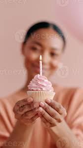 aniversário celebração com sorridente mulher segurando Rosa Bolinho e aceso  vela. feliz fêmea fazer desejo em aniversário sobremesa. perfeito festa  estilo de vida momento para especial ocasiões. 69202575 Foto de stock no