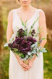 Wedding saturate purple rose bouquet of bride on grass. Deep Purple Wedding Bouquets