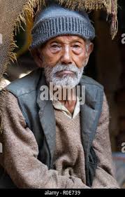 Unidentified bearded man sitting in chair, arm resting