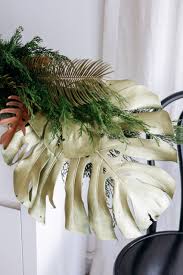 Gold Painted Monstera Leaf With Pine Garland Decoration For Christmas Tropical Christmas Christmas Settings Christmas Decorations