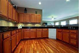 If you've ever wondered if you can use wood floors with oak cabinets, we have your answer. Golden Oak Cabinets Multicolored Floor Dark Counter Brown Walls Brown Cabinets Golden Oak Cabinets Brown Kitchen Cabinets