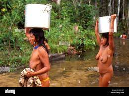 Mehinako Indígenas, Xingu, selva amazónica, Brasil. Mujer desnuda nativos  llevar las cacerolas aluminias Fotografía de stock 