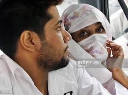 Pakistani Shamile Raj and his wife Shehzina Tariq sit in a police van...  News Photo