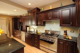 Stainless steel appliances, recess lights, stainless steel hood, and sink an outstanding example of uba tuba granite with shaker cherry golden honey color cabinets. Uba Tuba Granite Countertops Pictures Cost Pros Cons