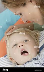 Mother brings her son to bed Stock Photo
