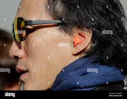 Chief lion dance instructor Rick Wing wears hearing protection during a  performance by the Wing Mo Athletic Association at the Ortega library  branch in San Francisco, Calif.