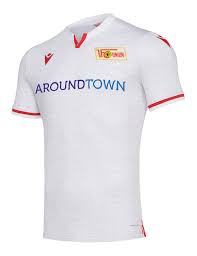 The white shirt has a crew neck collar with a red splash on the left neckline, housing a bear motif. Union Berlin 2019 20 Away Kit
