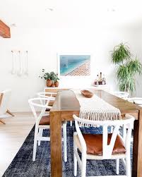 Interiors hsots of a modern kitchen in the foreground the white. Modern Coastal Dining Room With Indigo Rug Wood Table And White Wishbone Chairs Coastal Dining Room Modern Dining Room Tables Modern Coastal Dining Room