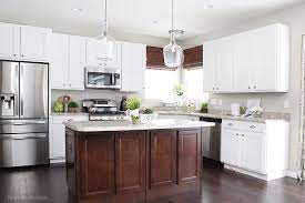 Large and luxurious kitchen with a white countertop island that has dark cabinets. Bar Stool Ideas How To Nest For Less