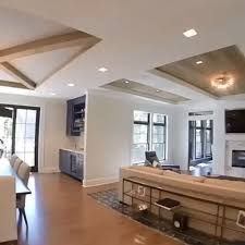 Light wood ceiling beams contrast with the room's dark gray walls and rich blue floor. Open Ceiling Living Room Design