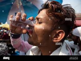 220429 -- NEW DELHI, April 29, 2022 -- A man drinks water during a hot day  in New Delhi, April 29, 2022. Indian capital region Delhi Friday continued  to reel under a
