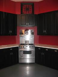 A pop of red keeps this basic kitchen from looking dull. Why Black Kitchen Cabinets Aboutcabinets Net Black And Red Kitchen Black Kitchens Red Kitchen Cabinets