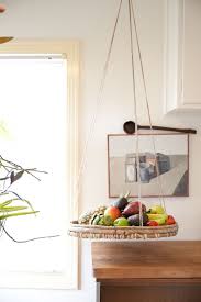 Three concentric baskets in a tiered construction, perfect for displaying fruit + plants in the kitchen with cotton net for base + edges with rounded wooden structure. 4 Hanging Baskets That Will Save Your Little Kitchen From Big Clutter Architectural Digest