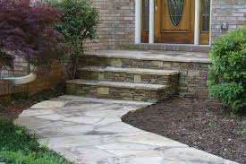 A quant stepping stone path crosses through a cute front garden as it wraps around the front of this century home. Walkway Ideas Front Door Steps Flagstone Steps Patio Steps