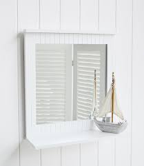 Quite literally reflective, a bathroom mirror is a traditional and functional addition to full baths and powder rooms alike. White Bathroom Mirror With A Shelf For Coastal Nautical Home Interiors