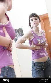 Teenager Mädchen Spiegel betrachten und prüfen ihre Brust Stockfotografie -  Alamy