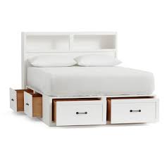 The simple platform bed frame has three pullout drawers on one side, all of which have plain fronts (no handles or notches) and sit flush side by side. Stratton Storage Bed Headboard Pottery Barn