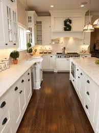 While some are unfinished some cabinets are finished. White Kitchen Shaker Cabinets Hardwood Floor Black Pulls White Kitchen Design Kitchen Design Kitchen Cabinet Design