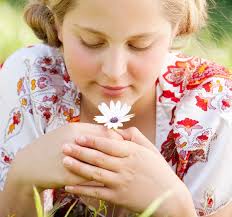 Close up portrait of a young girl holding a white daisy flower in her hand  against the sky — Stock Photo © mjth #20205005