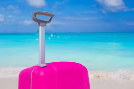 Es lässt sich im übrigen. Rosa Koffer Am Strand Stock Foto