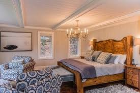 This basement bedroom has all the hallmarks of upstairs comfort, with a bright window, fluffy duvet, and rustic wood accents. Low Ceiling Bedroom Love The Bed Ceiling And That It Has A Chandelier Low Ceiling Bedroom Master Bedroom Remodel Chandelier Bedroom