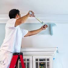A Painting Contractor Rolls Blue Paint Onto A Wall Painting Contractors Interior Paint Painting Services