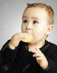 Young Boy Eating A Biscuit Against A Grey Background Stock Photo, Picture  and Royalty Free Image. Image 13486262.