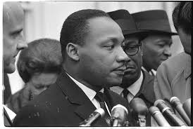 Martin Luther King, Jr., head-and-shoulders portrait, facing right, at  microphones, after? meeting with President Johnson to discuss civil rights,  at the White House, 1963]