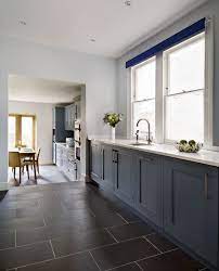 A wall of green cabinets with natural wood shelves adds to this kitchens organic vibe. Hand Painted Dark Blue Cabinets Have Been Paired With These Gorgeous Black Slate Tiles Kitchen Flooring Ideas Inexpensive Slate Kitchen Black Tiles Kitchen