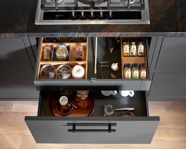 Deep kitchen drawer organised with pots pans plates and kitchen utensils