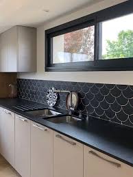 a monochromatic kitchen with black countertops black frames and a black fishscale tile in 2021 kitchen design modern small modern kitchen design kitchen window design