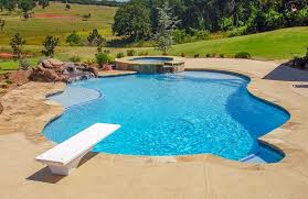 Professional sporty male swimmer jumping off into the swimming pool from starting block at indoor pool. Changing Depth Of A Swimming Pool Benefits Of Shallowing The Deep End